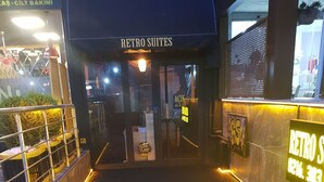 A building entrance with a sign reading "RETRO SUITES" and a neon sign with the number "1216.303". - Retro Suites (Istanbul)