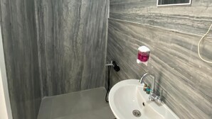 A bathroom with a white sink, a mirror, and a shower area. - Retro Suites (Istanbul)