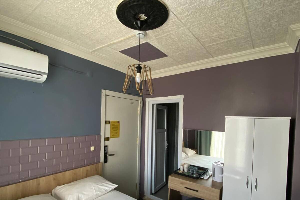 Een hotelkamer met een bed, een bureau, een kledingkast en een airconditioningsysteem.