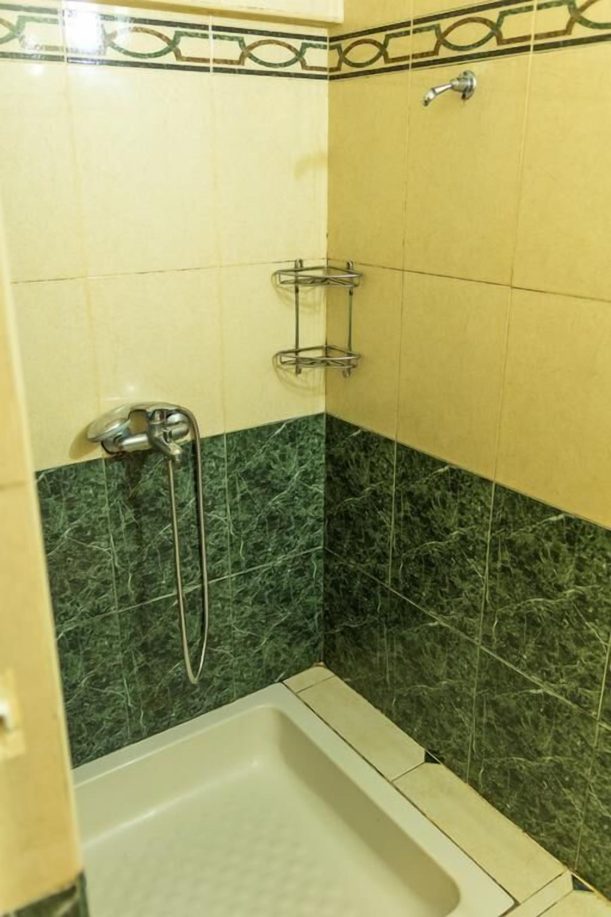 Une salle de bain avec une douche, une baignoire et des toilettes.