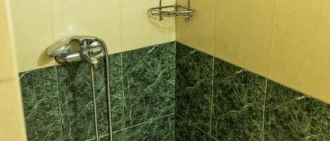 Un baño con ducha, bañera y retrete.