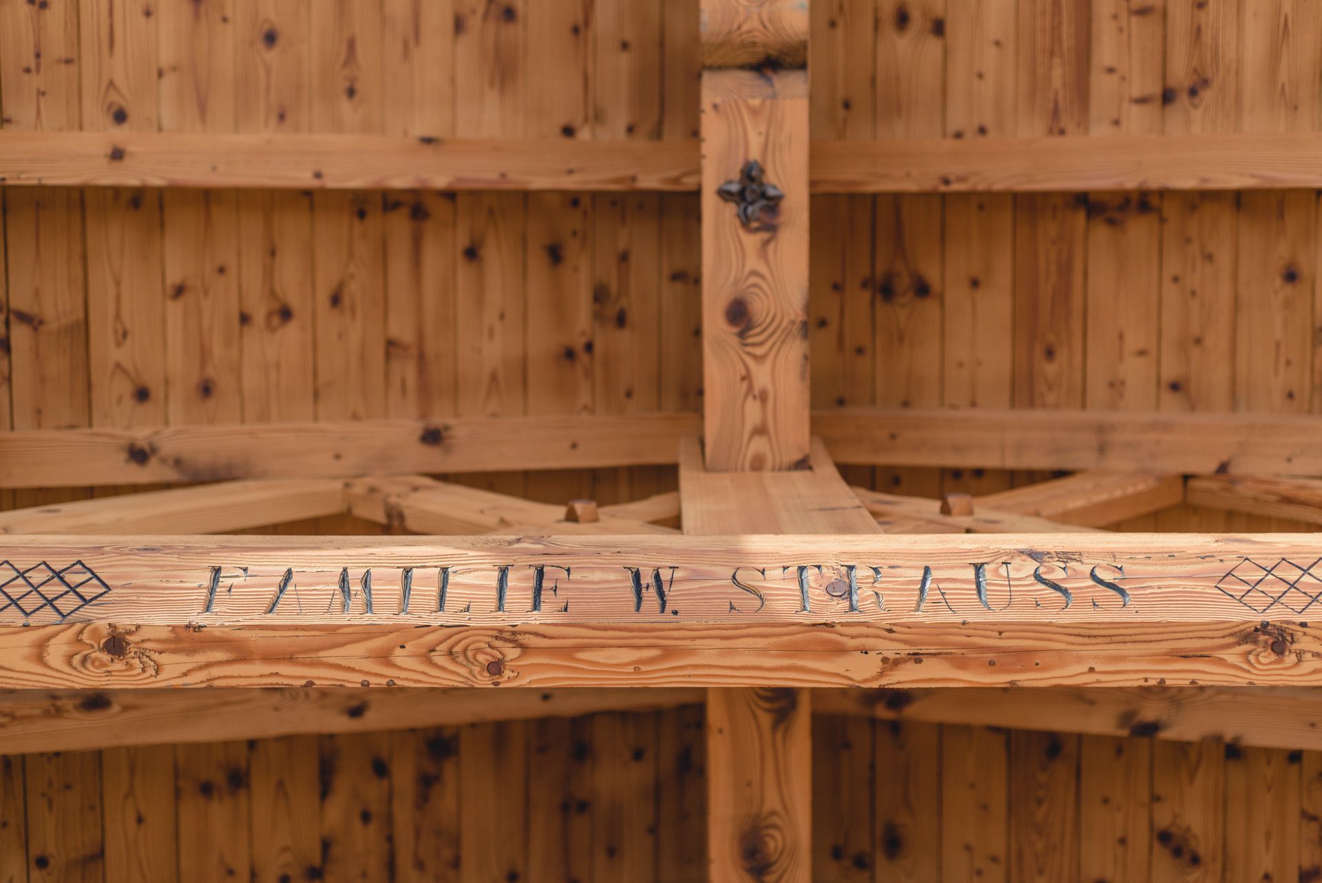 Une structure en bois avec une poutre transversale portant l’inscription « JULIE W. STRAUSS ».