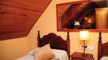 Un dormitorio con techo de madera, una cama con cabecera, una mesita de noche con una lámpara y un espejo en la pared.
