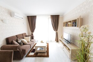 Leilighet – deluxe, 1 soverom | Oppholdsområde | En 0-tommers Flatskjerm-TV med Parabol-TV samt TV