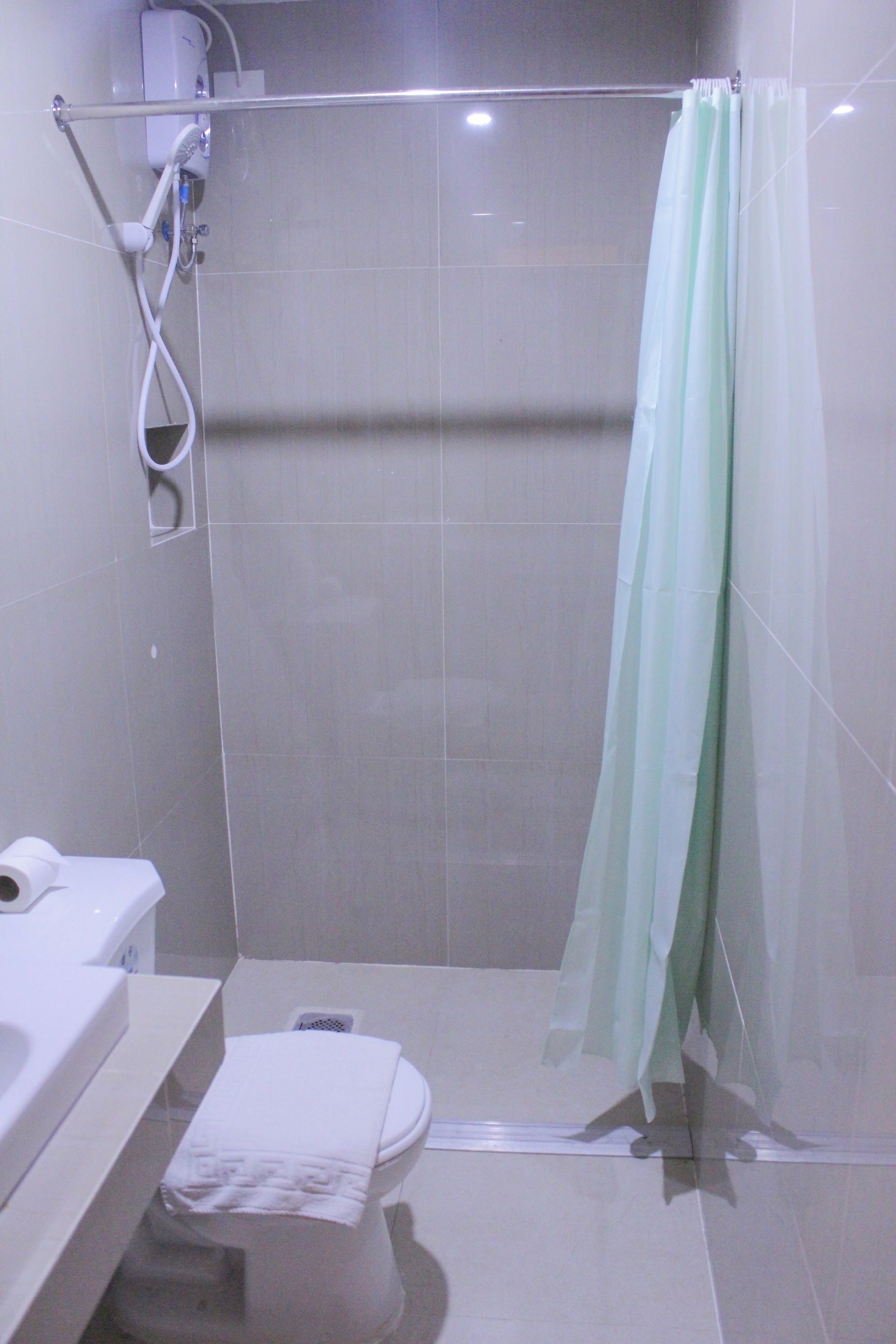 A bathroom with a shower, toilet, and sink.