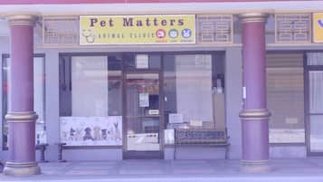 A pet clinic named 'Pet Matters' with a signboard, a bench outside, and a glass door.