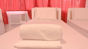 A hotel room with a bed, a bedside table, and a wall-mounted heater. - Butuan Grand Palace Hotel Annex (Butuan)