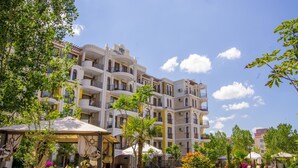Un hôtel à plusieurs étages doté de balcons, d’un espace extérieur aménagé et d’une piscine.