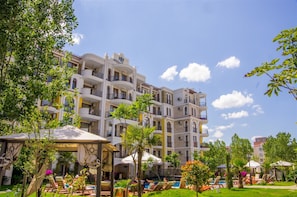 Un hôtel à plusieurs étages doté de balcons, d’un espace extérieur aménagé et d’une piscine.