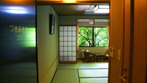 A traditional Japanese room with tatami flooring, a shoji screen, and a view of greenery outside. - Asia Hotel Fujisan (Yamanakako)