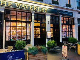 Exterior do Hotel Waverley, com lounge de bar e placa indicando jardim de cerveja.