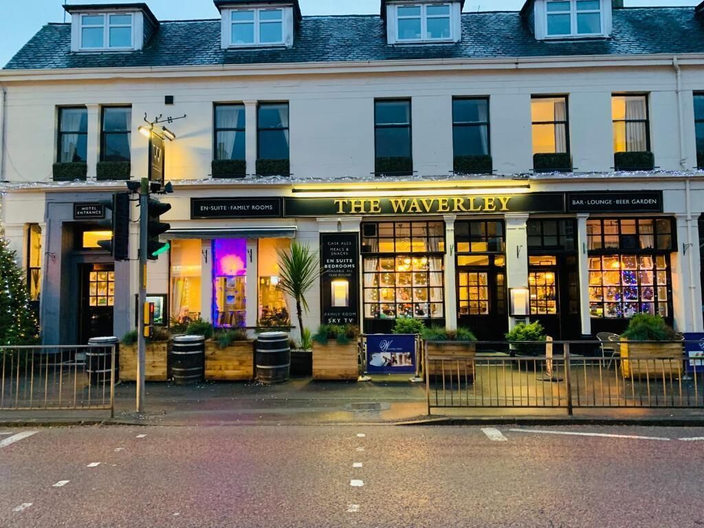 A hotel named 'The Waverley' with a bar lounge and beer garden. It has a traditional facade with multiple windows and a sign indicating en-suite family rooms.
