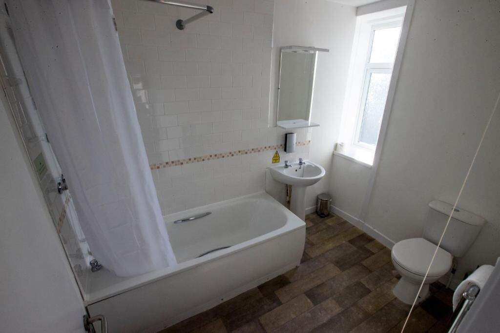 Un baño con bañera, lavamanos e inodoro.