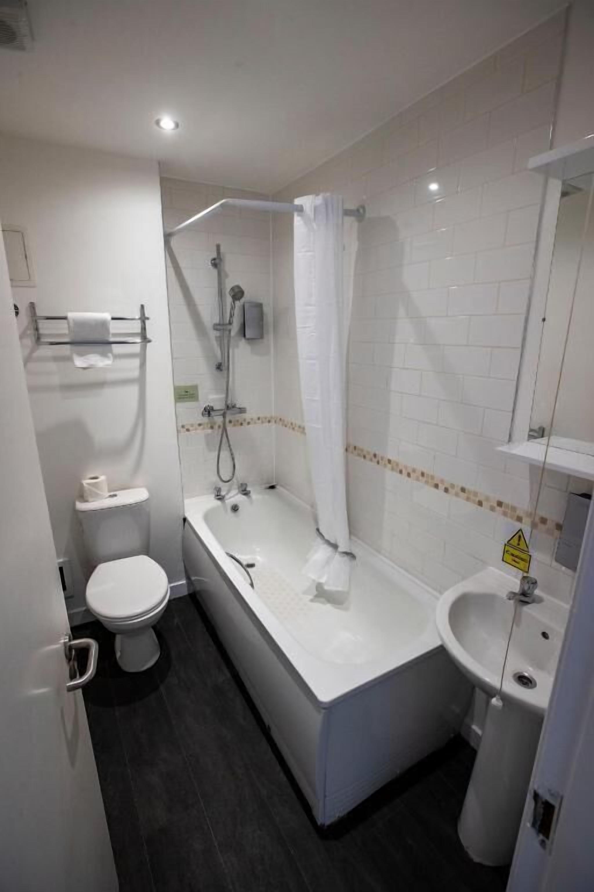 Un baño con bañera, inodoro y lavamanos.