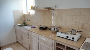 A kitchen with a sink, a stove, and a countertop. - Yialos Studios (Agistri)