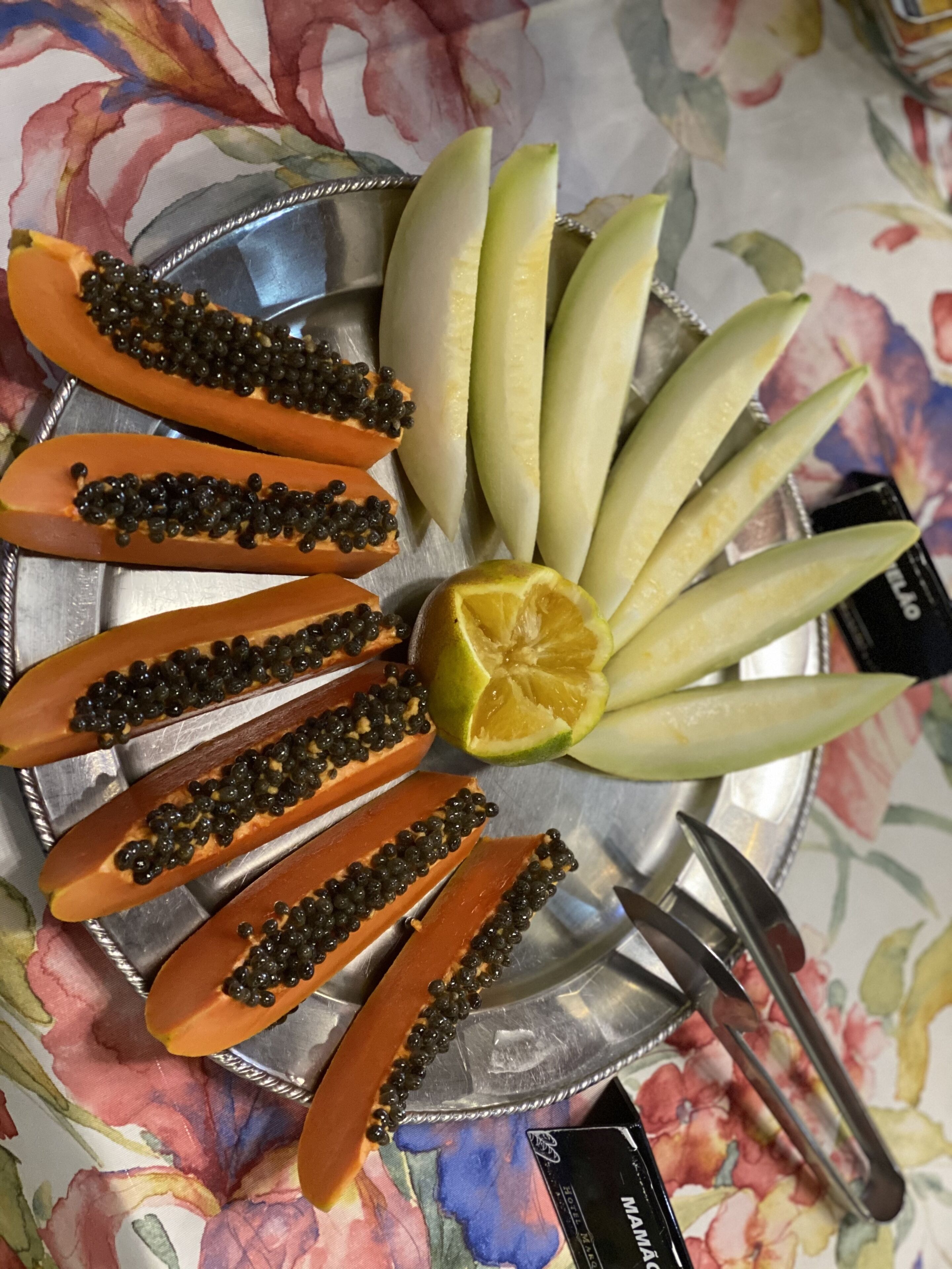 Ein Teller mit Papaya Scheiben und einem Limettenschnitz.
