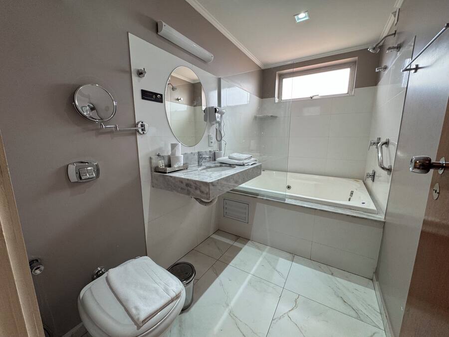 A modern bathroom with a bathtub, toilet, and vanity.