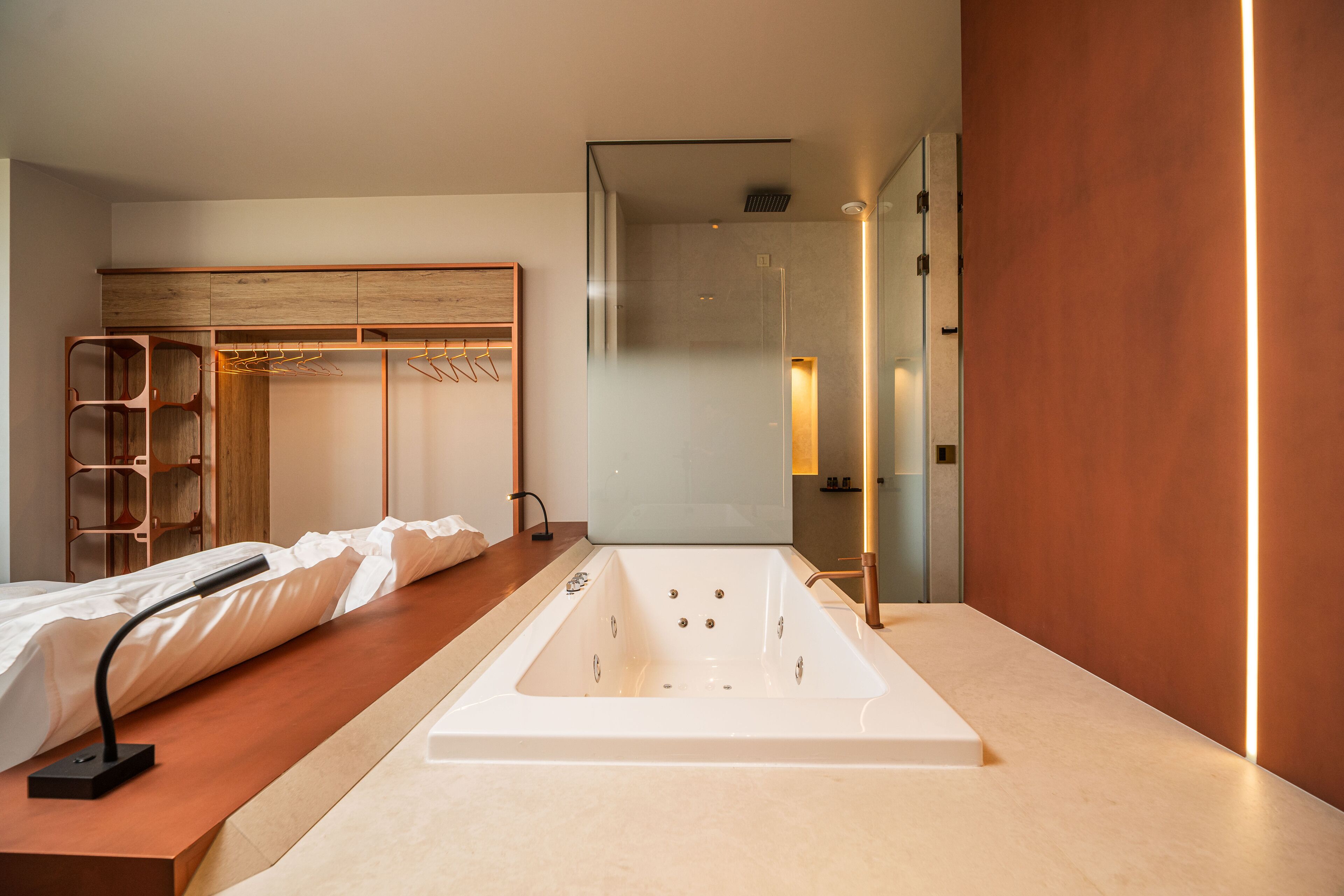 Un baño moderno con una bañera independiente, un tocador de madera y una ducha a ras de suelo.
