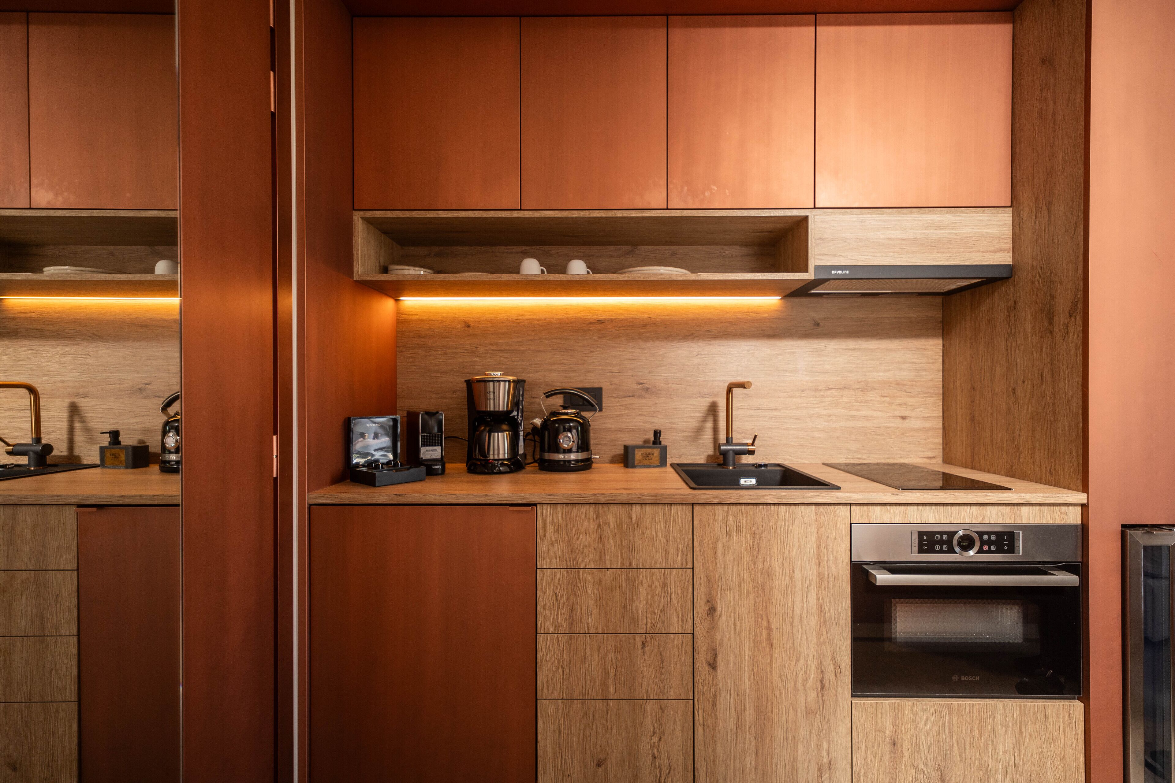 A compact kitchen with wooden cabinets, a Bosch oven, and a coffee maker.