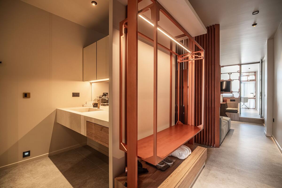 A modern bathroom with a wooden vanity, a built-in bench, and a shower area.
