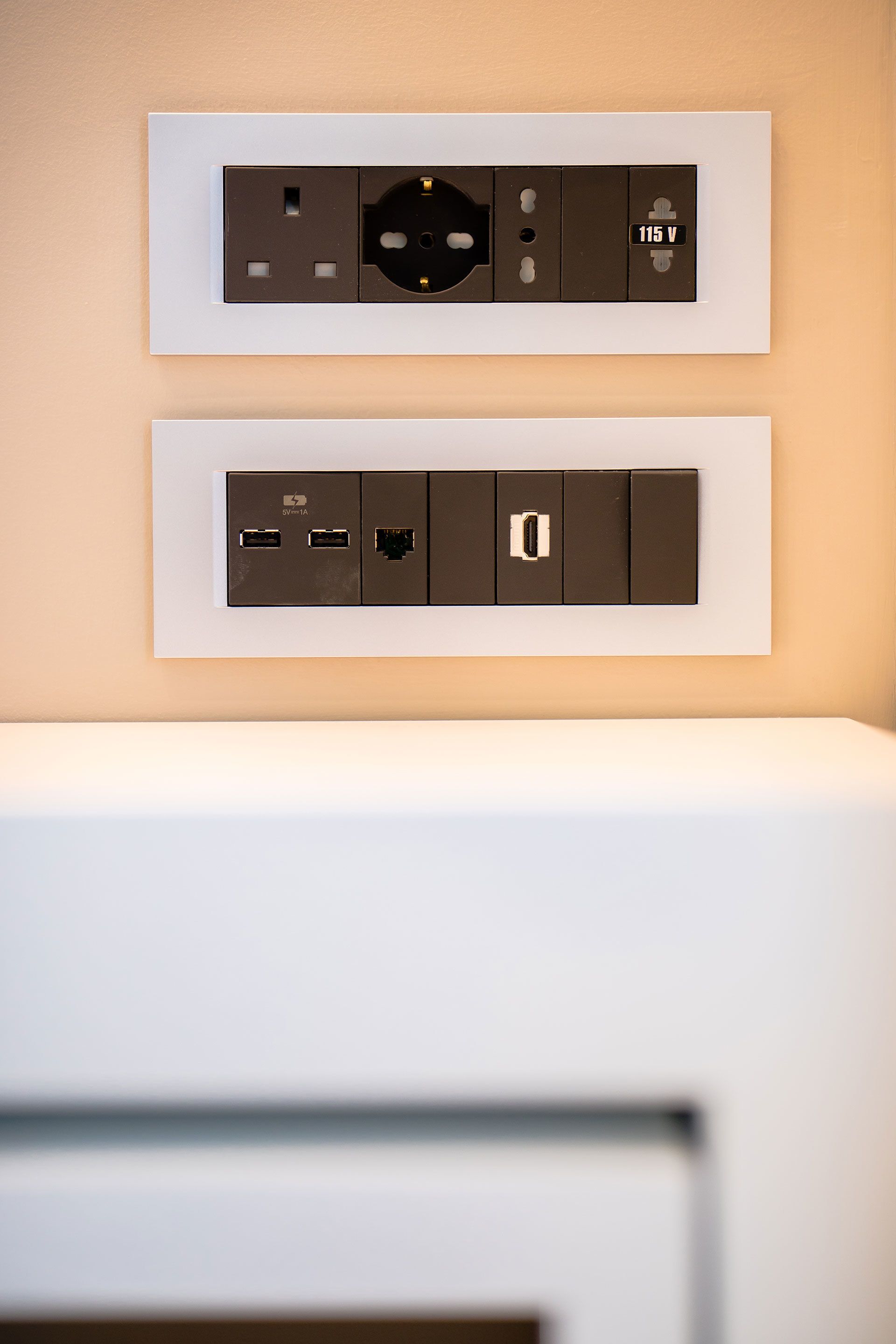 A wall-mounted electrical panel with a power outlet and a USB charging station.