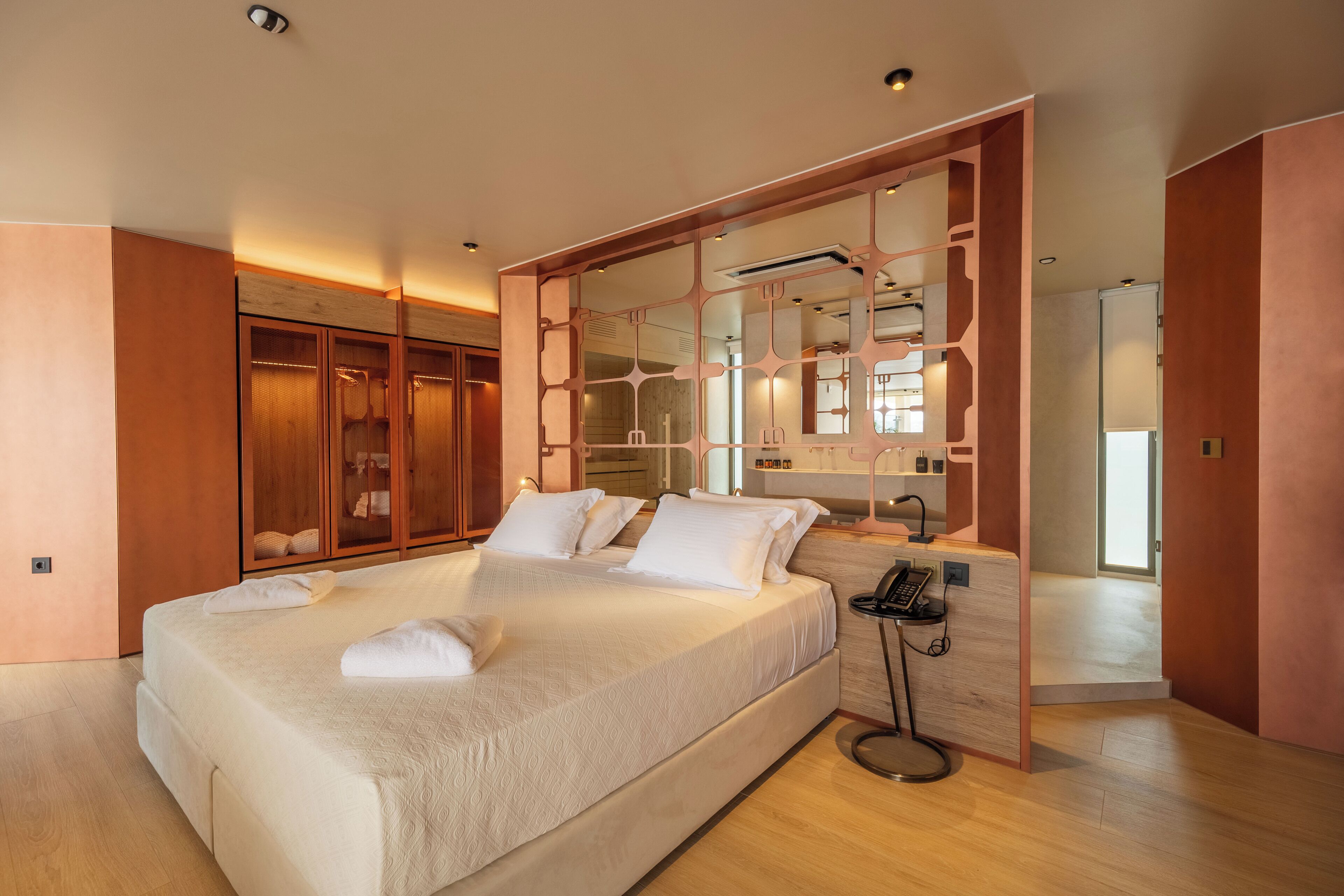 A modern bedroom with a large bed, wooden wardrobe, and a mirror.