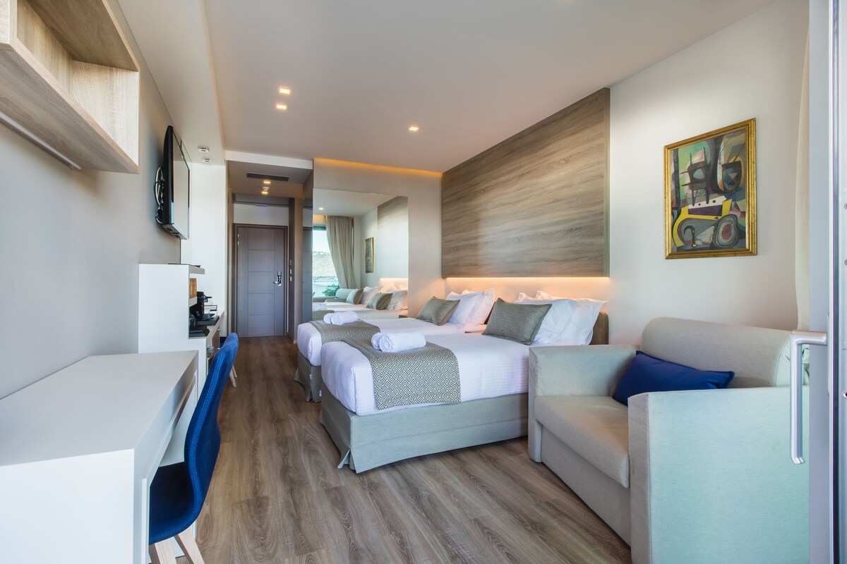 Une chambre d’hôtel moderne équipée d’un lit, d’un bureau, d’une chaise et d’un canapé.