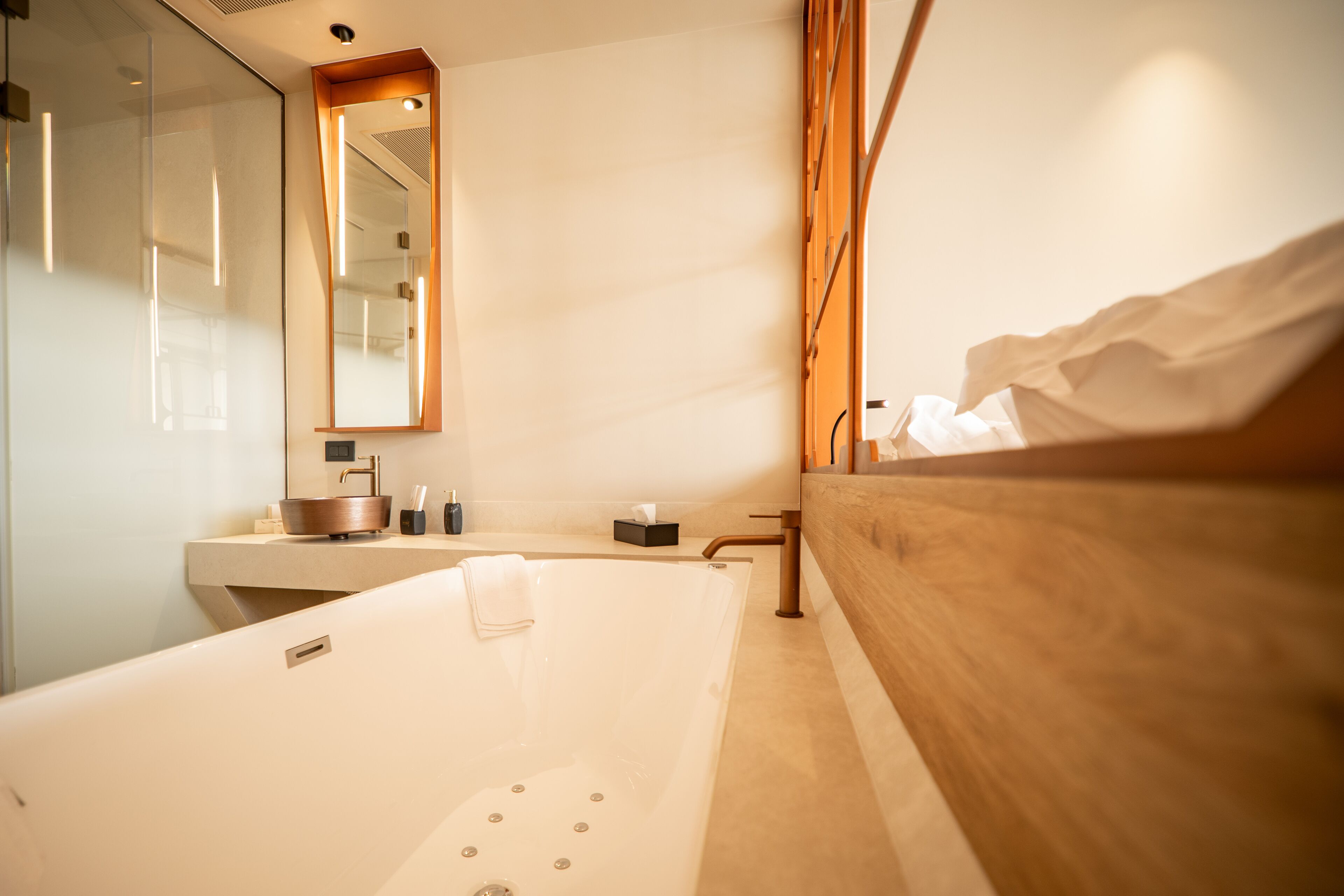 Un baño moderno con bañera, tocador de madera y un espejo grande.