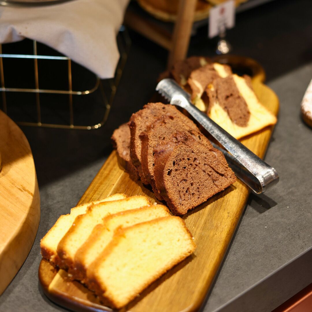 A wooden cutting board with slices of cake and a knife.