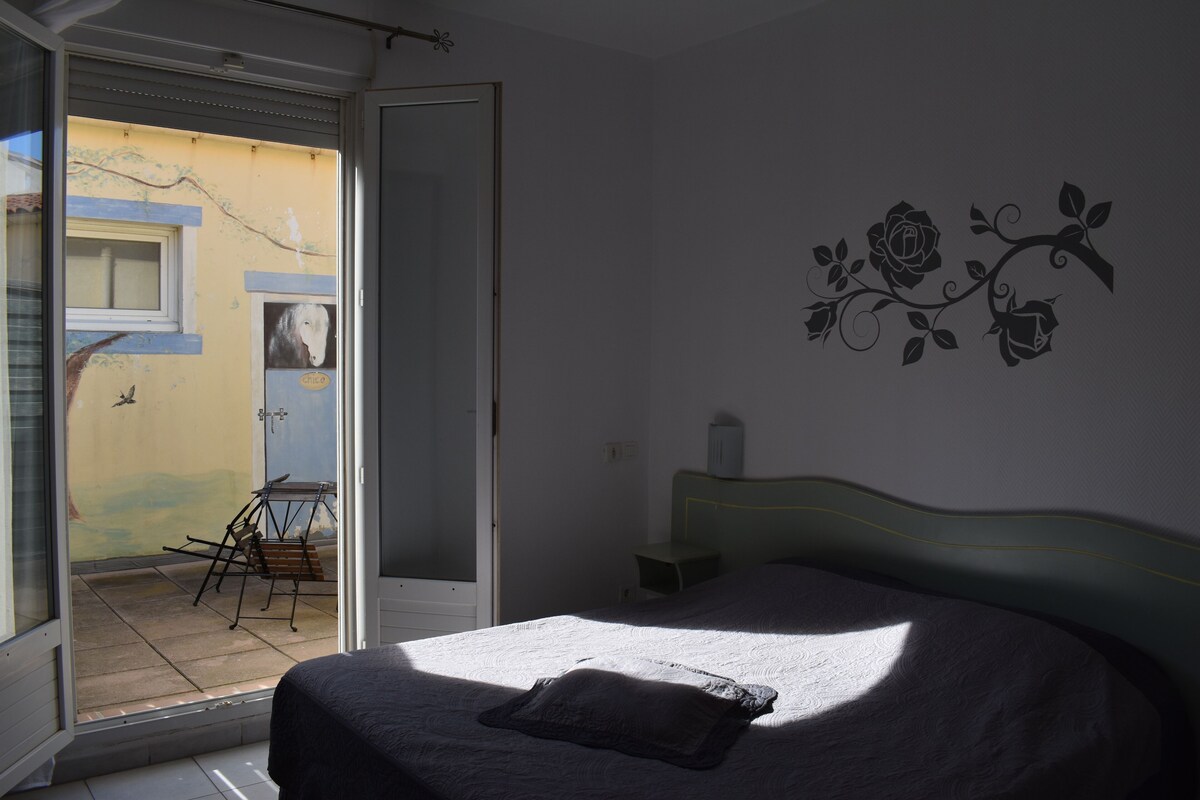 A bedroom with a bed, a window, and a wall decoration.