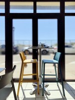 Una mesa con dos sillas, vista al estacionamiento y un edificio al fondo.