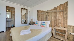 Een slaapkamer met een groot bed, een houten hoofdbord en een nachtkastje met een beeldje.