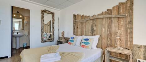 A bedroom with a large bed, wooden headboard, and a nightstand with a statue.