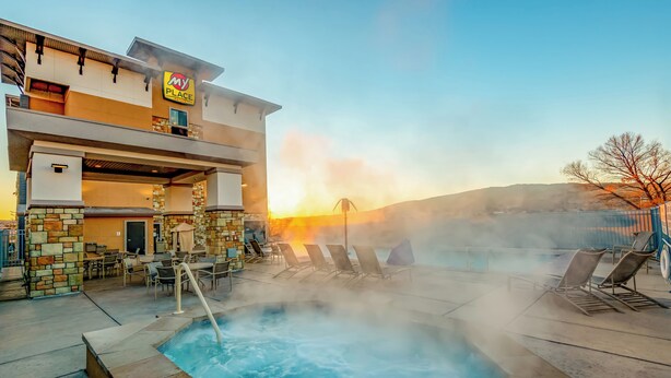 Un hôtel doté d’une piscine, d’un espace extérieur aménagé et offrant une vue sur le coucher de soleil.