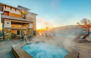 A hotel with a pool area, outdoor seating, and a view of the sunset. - My Place Hotel - St. George, UT (St. George)