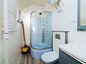 A modern bathroom with a glass-enclosed shower, a white toilet, and a sink with a mirror. - Balticus (Postomino)