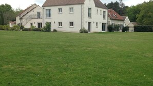 A large, white, two-story building with a tiled roof, surrounded by a grassy field. - Domaine de la Motte Melleraye (Donnery)