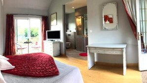 A bedroom with a bed, a desk, a TV, and a view of the outside. - Domaine de la Motte Melleraye (Donnery)