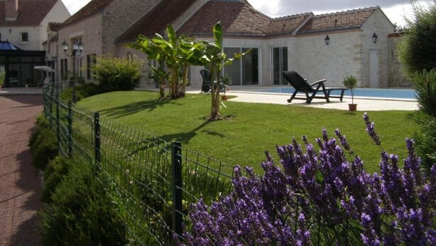 A courtyard with a swimming pool, a covered seating area, and a stone building with a tiled roof. - Domaine de la Motte Melleraye (Donnery)