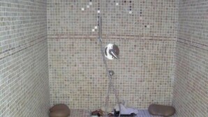 A small, tiled room with a shower area, including a showerhead and a drain. - Domaine de la Motte Melleraye (Donnery)