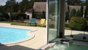 A swimming pool with a hot tub adjacent to a glass door. - Domaine de la Motte Melleraye (Donnery)