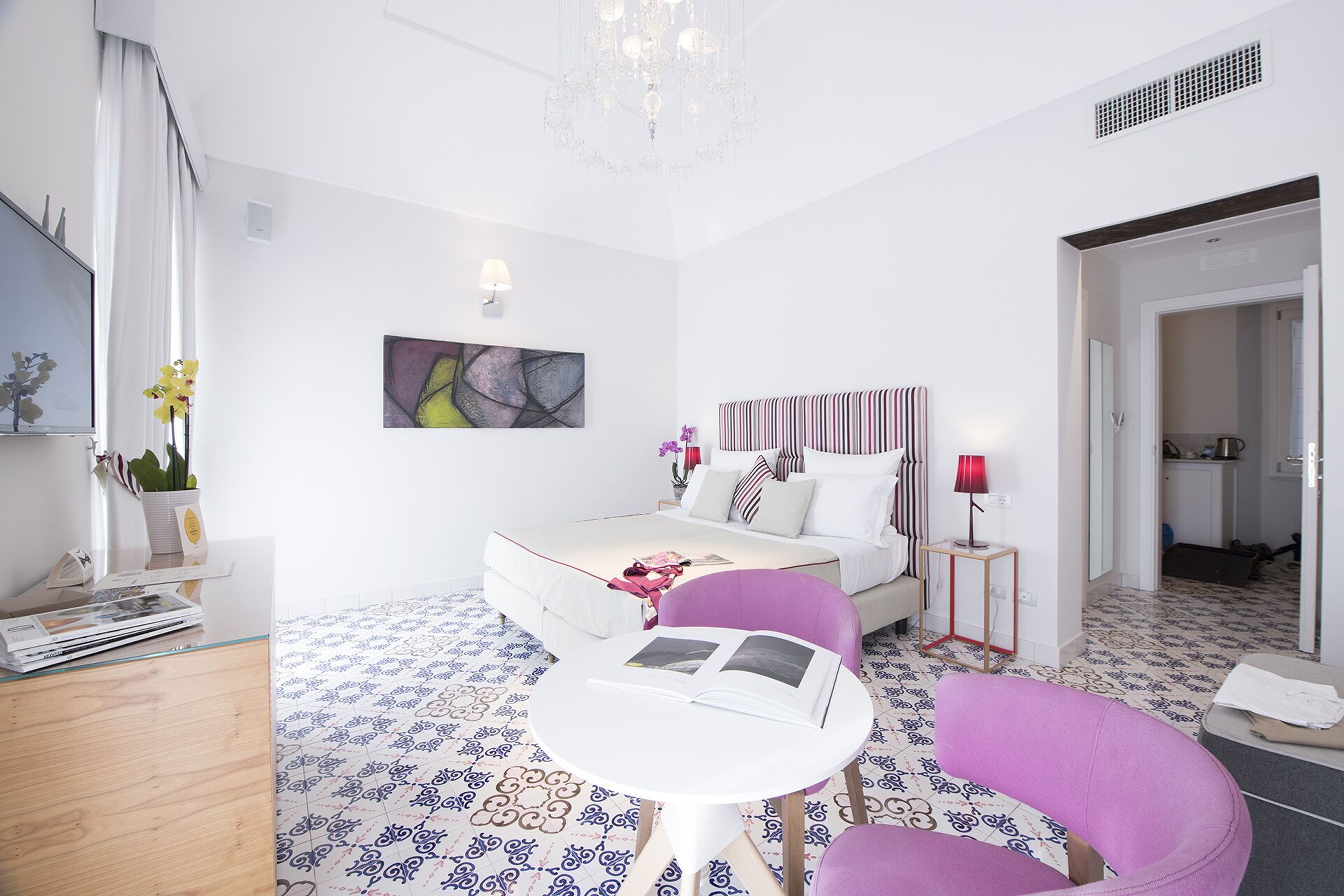 Un dormitorio moderno con cama, mesita de noche y una silla.