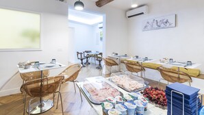 A dining area with tables, chairs, and a buffet with food items.