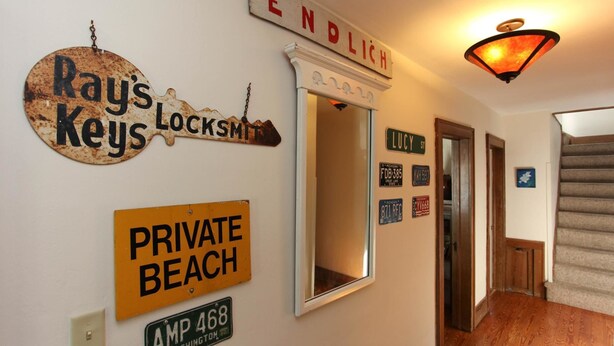 A hallway with a vintage sign reading "Rays Keys Locksmith," a "Private Beach" sign, and a street sign for "LUCY ST."