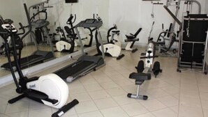 A gym with various exercise equipment including treadmills, stationary bikes, and weight machines. - Hotel Moatize (Moatize)