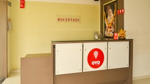 Ein Empfangsbereich mit einem Schild, auf dem 'RECEPTION' steht, und dem Logo von 'OYO ROOMS'.