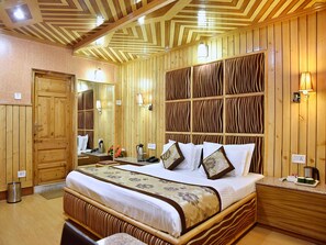 Une chambre d’hôtel à thème, décorée dans un style rustique, avec un grand lit, des tables de chevet, un miroir et un luminaire fixé au mur.