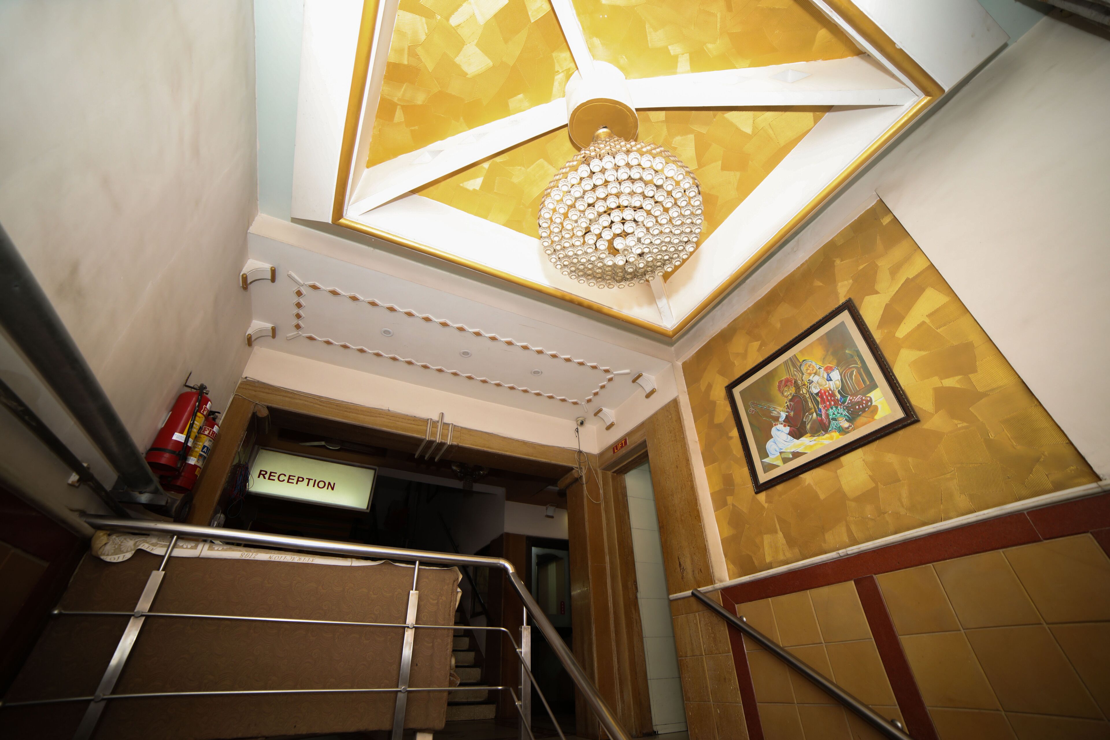 A reception area with a sign, a chandelier, and a framed artwork on the wall.