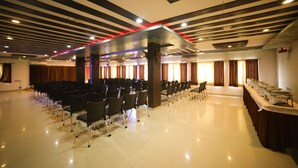 A spacious hall with rows of chairs, a buffet table, and a modern ceiling design. - Hotel Vrundavan Residency (Vadodara)