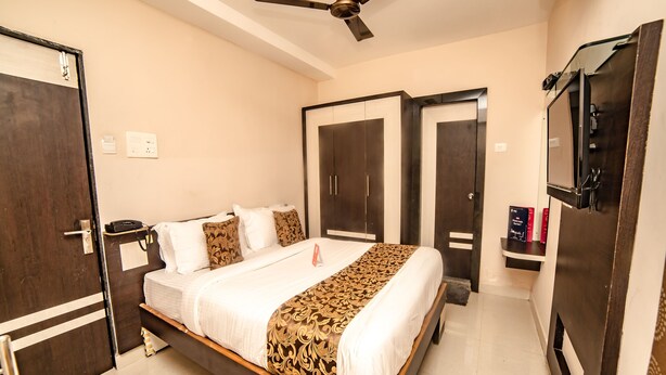 Une chambre d’hôtel avec un lit, une armoire et un ventilateur de plafond.